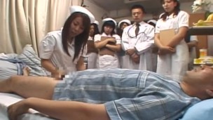 Demonstration Day at Japanese Hospital Featuring a Group of Nurses Watching a Patient Being Milked Before Joining In